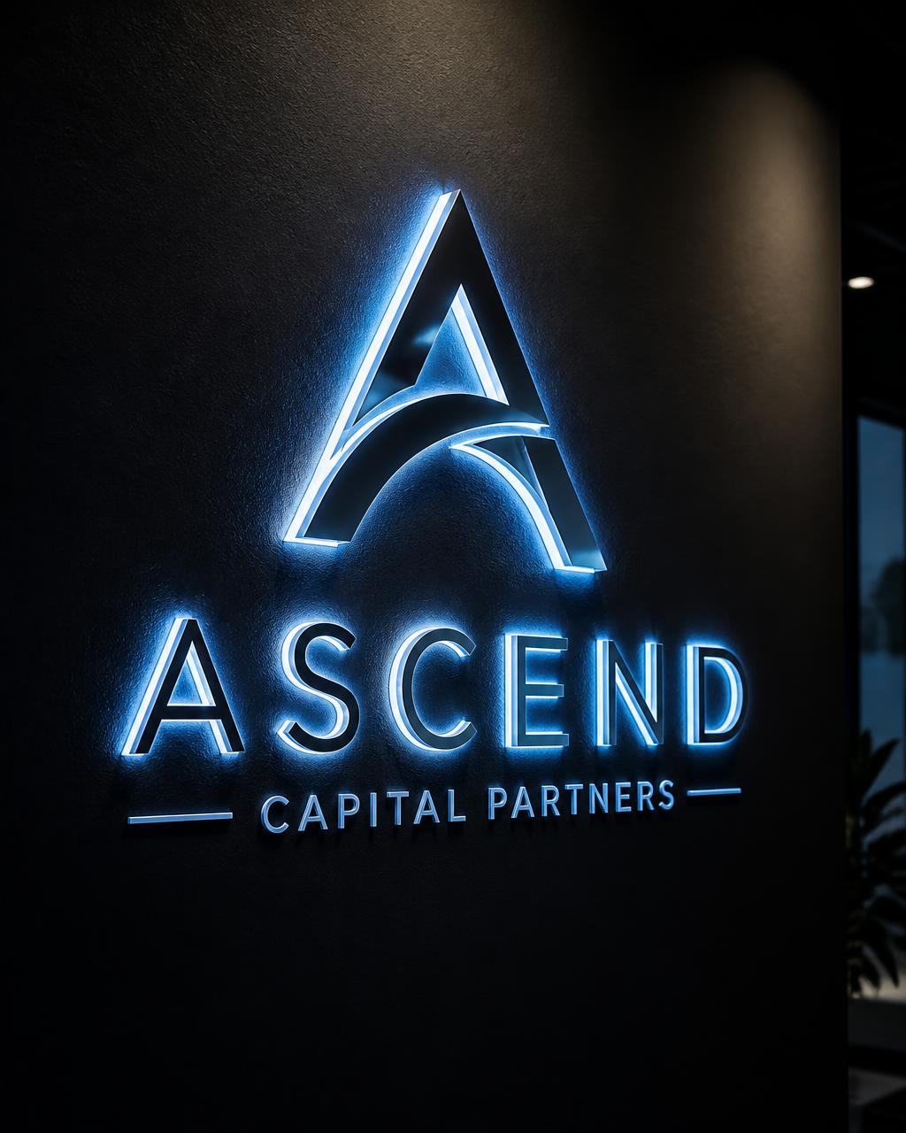 Backlit acrylic logo sign glowing cool blue on a dark wall